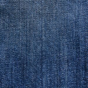 Textured blue denim fabric with detailed weaving visible in close-up macro view.